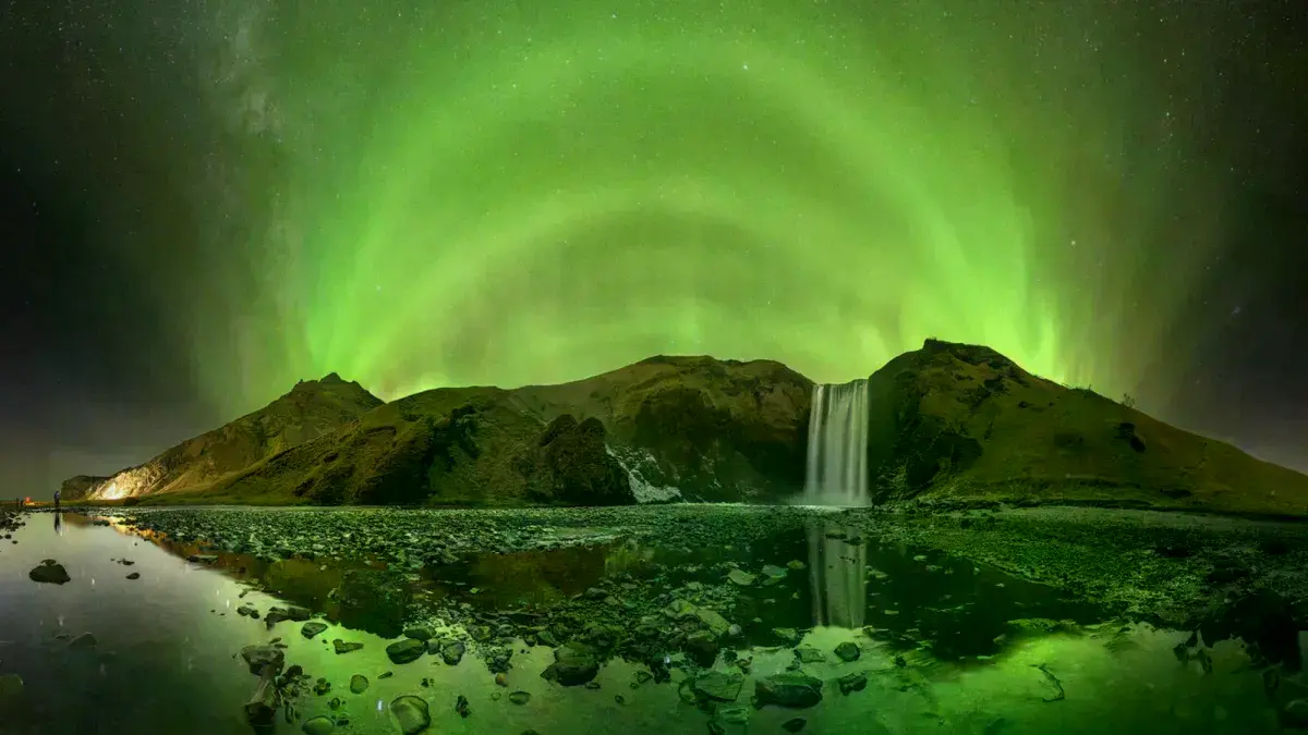 Aurora boreal sobre la cascada Skógafoss en Islandia, capturada por Victor Lima.
