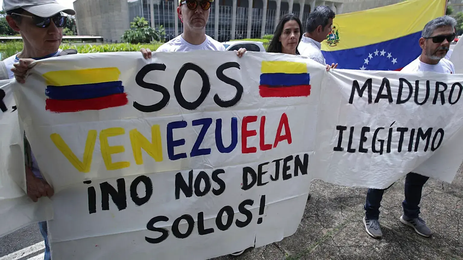 Ciudadanos venezolanos residentes en Brasil sostienen carteles de protesta en 2019.