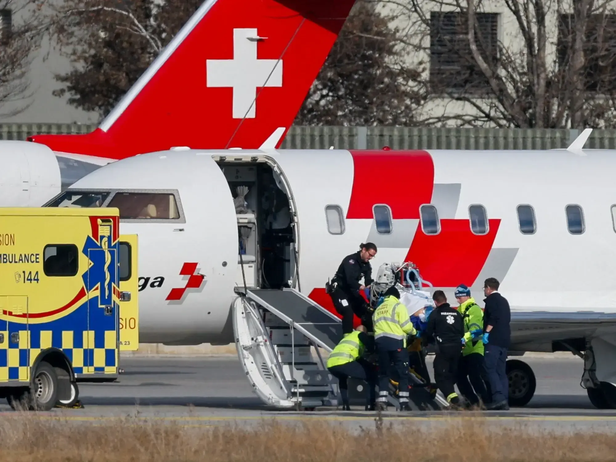 Personal médico traslada a un herido en un avión hospital.