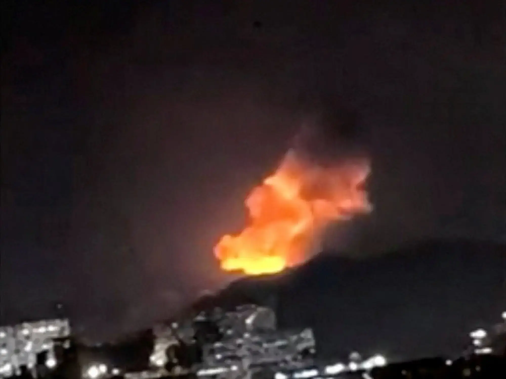 Una columna de humo se eleva durante múltiples explosiones en la madrugada del 3 de enero de 2026 en Caracas, Venezuela.