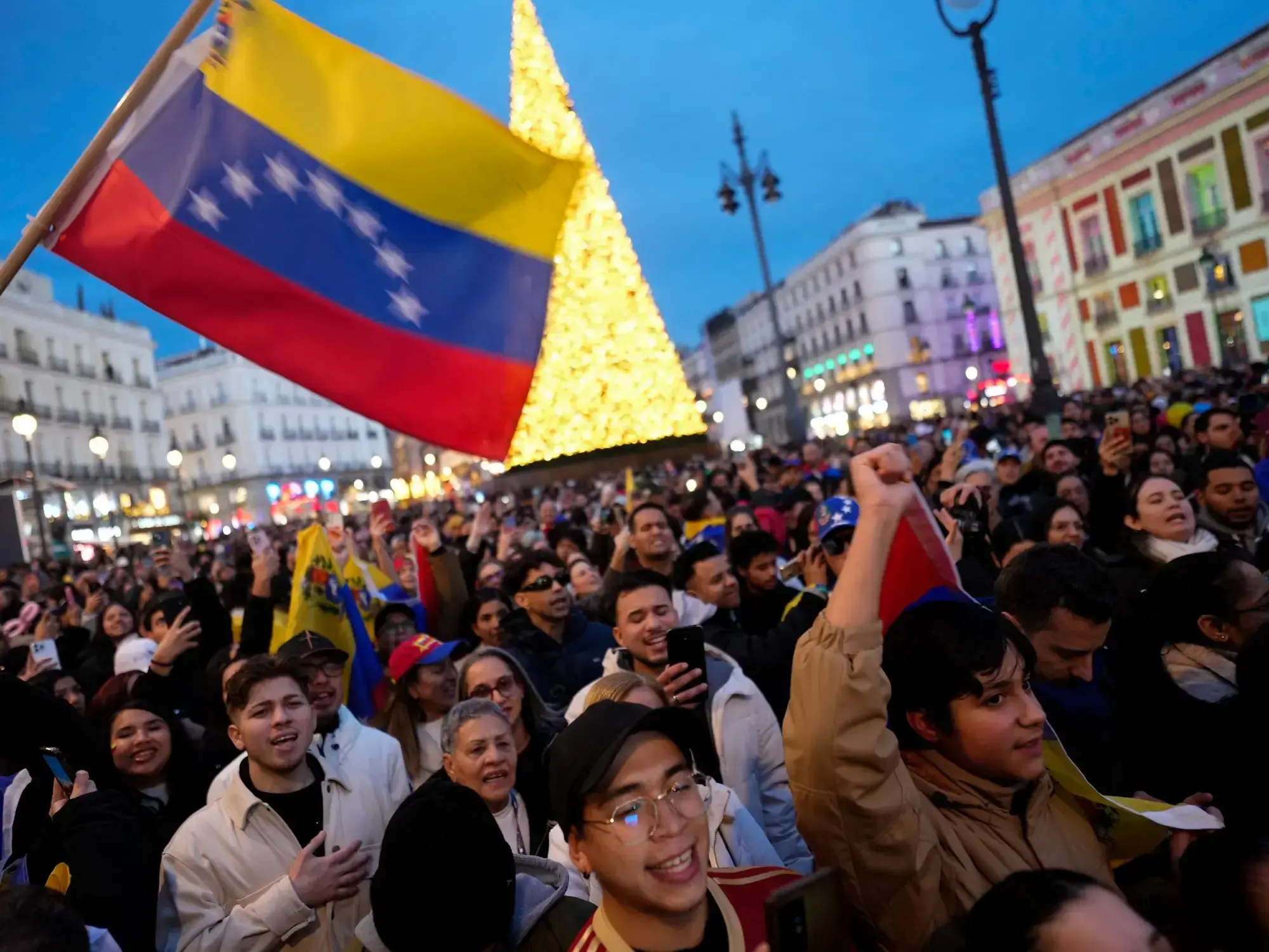 Multitud de venezolanos celebra en Madrid la captura de Nicolás Maduro.