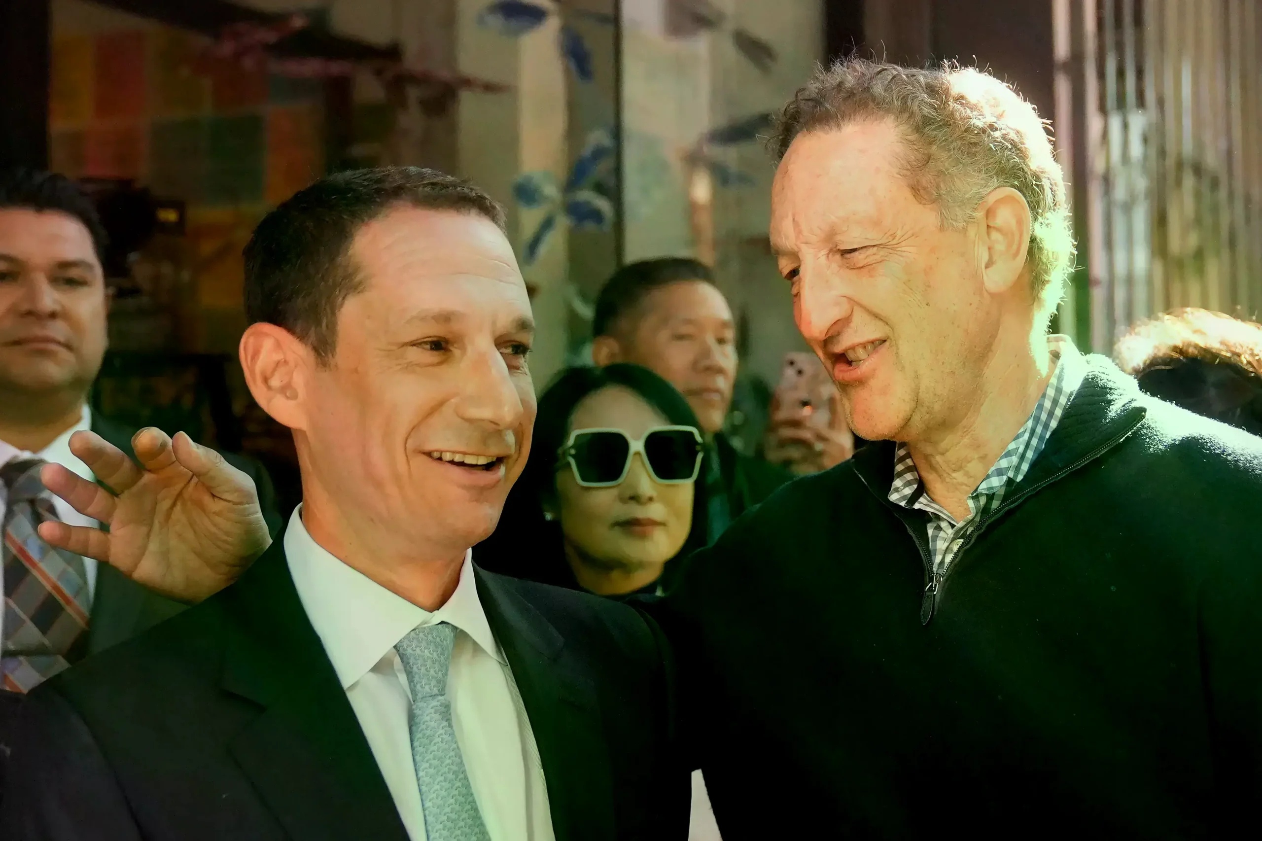 Daniel Lurie habla con el CEO de los San Francisco Giants, Larry Baer, en Chinatown.