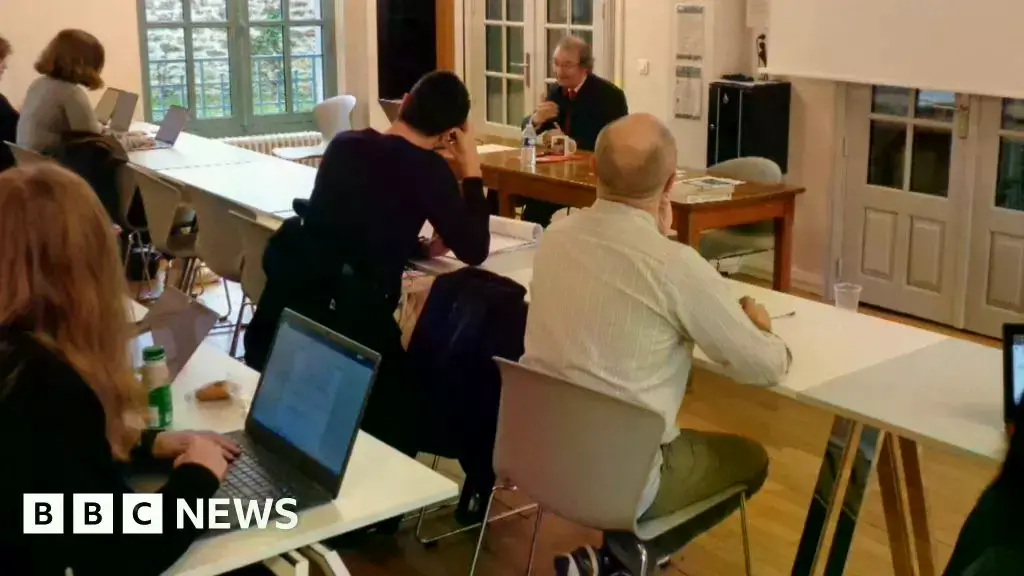 Un profesor imparte clase a estudiantes, entre los que se encuentran agentes secretos.