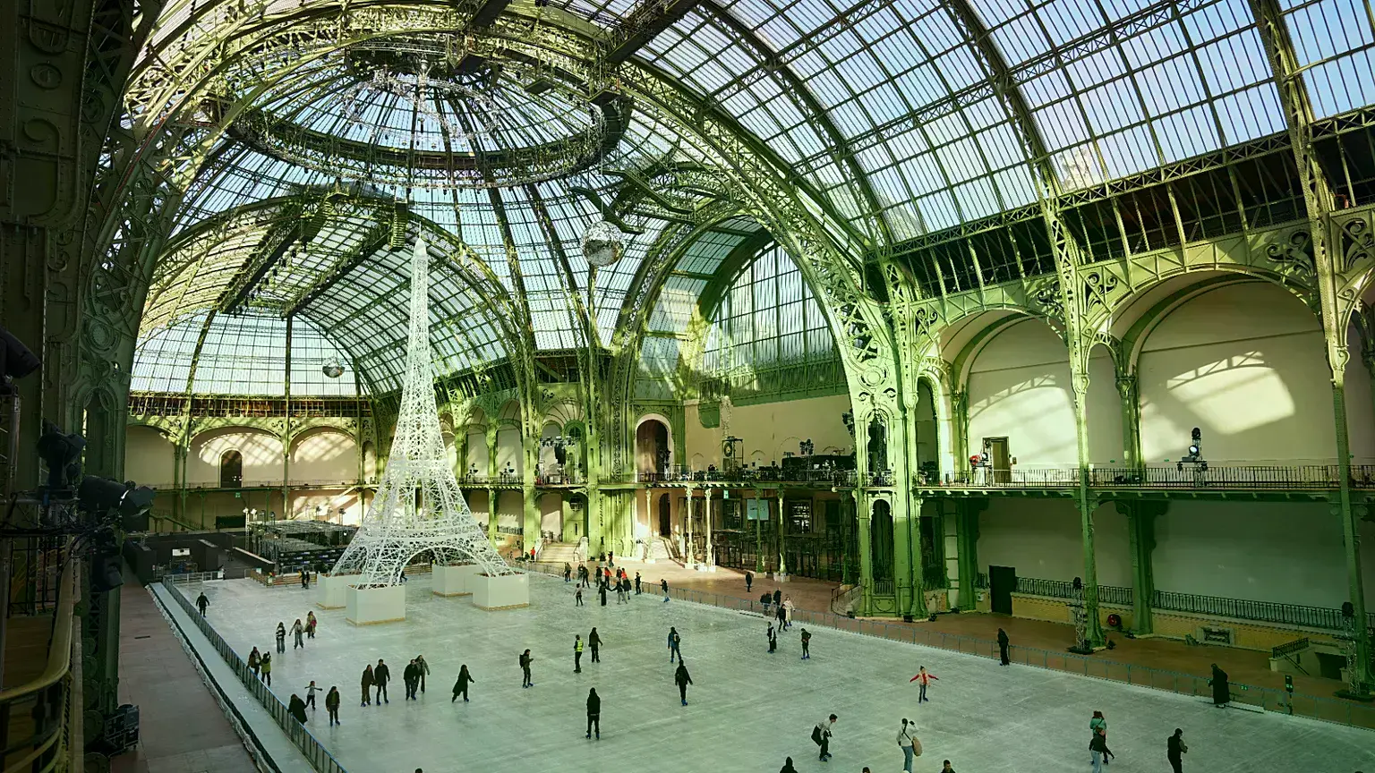 La gente patina en una pista de hielo del Grand Palais, en París.