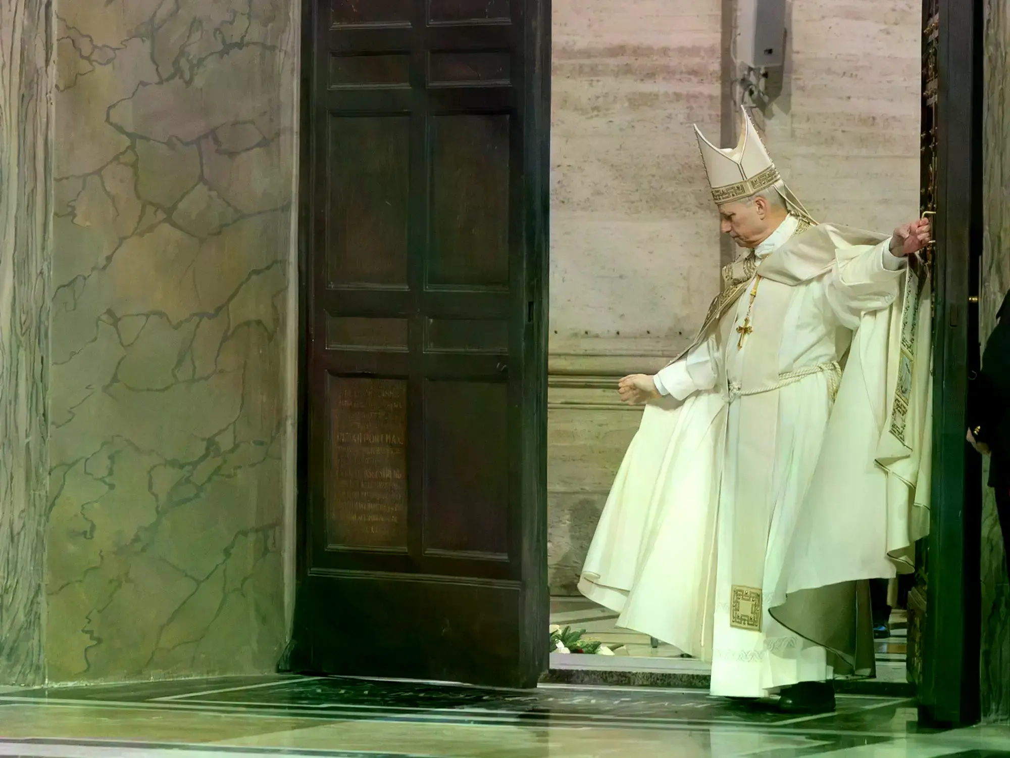 El Papa León XIV se arrodilla para rezar ante la Puerta Santa de San Pedro antes de cerrarla.