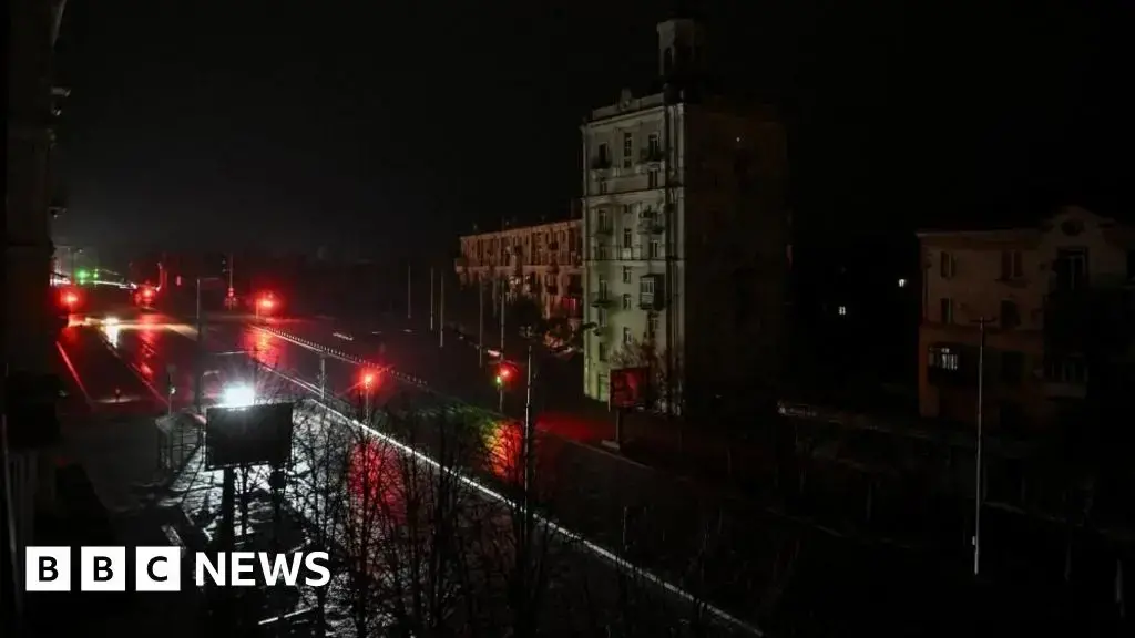 Coches circulan por una calle oscura durante un apagón en Zaporiyia.