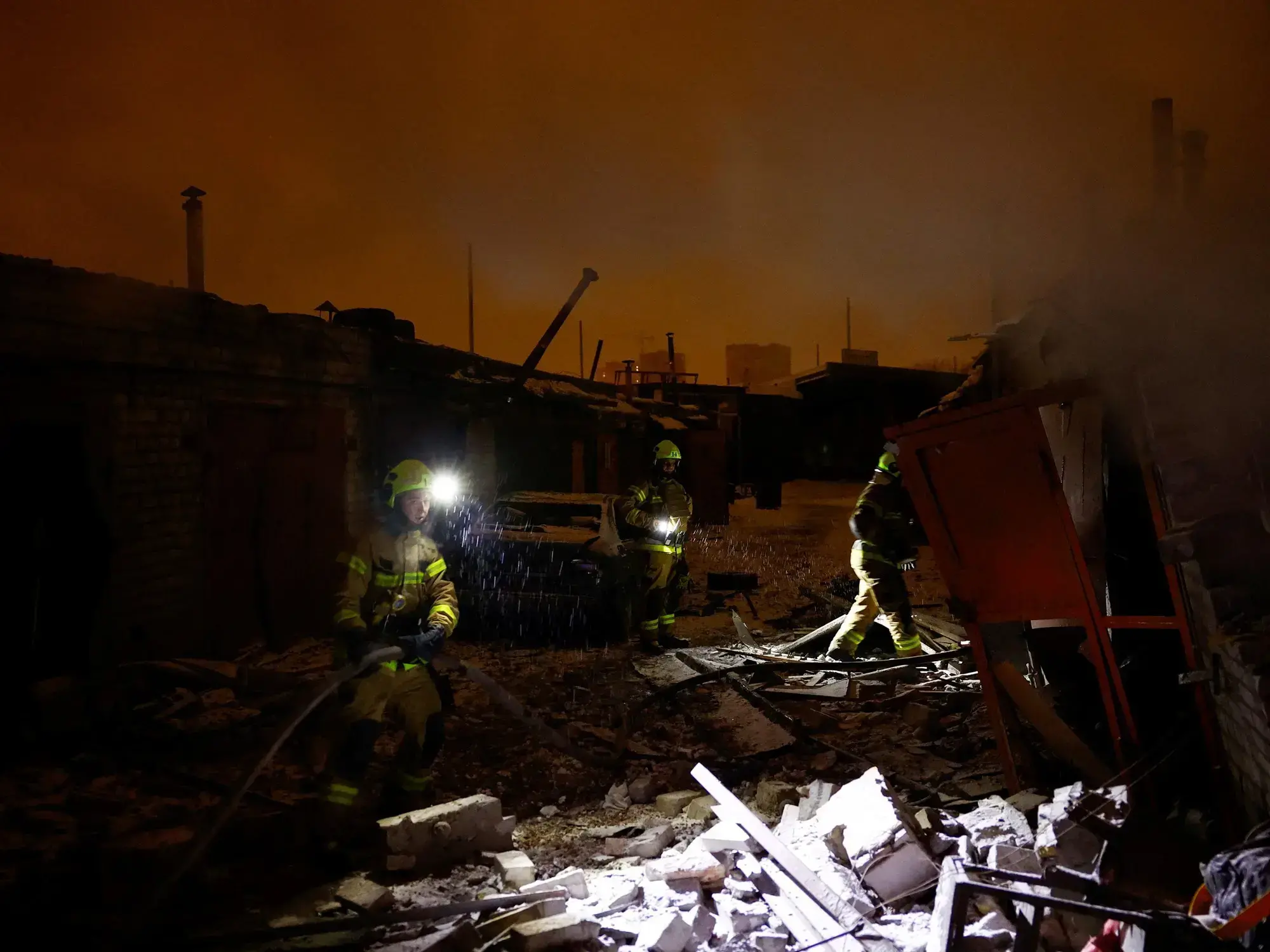 Bomberos trabajan en un complejo de talleres dañado durante un ataque ruso en Kiev.