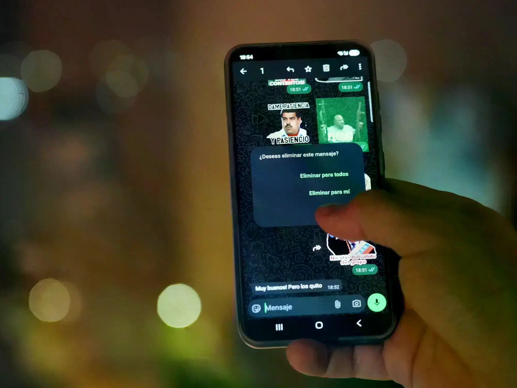Venezolano revisando su teléfono móvil en la calle.
