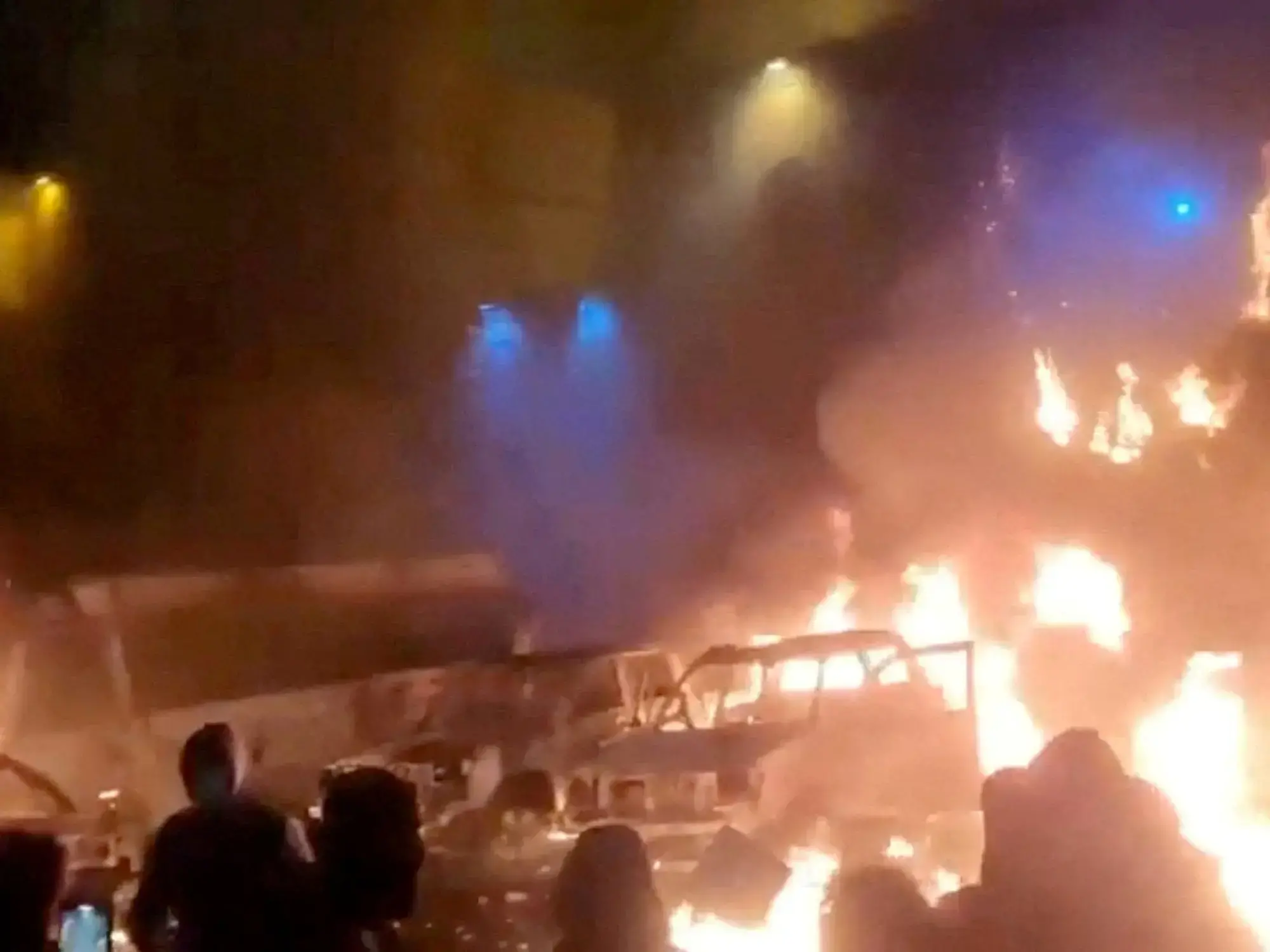 Manifestantes se reúnen mientras se queman vehículos en Teherán, Irán.