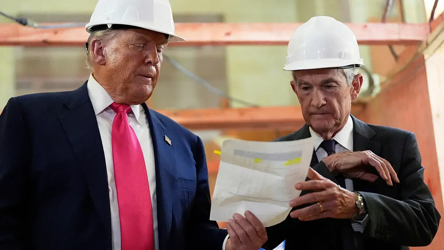 Jerome Powell y el presidente Donald Trump revisan un documento durante una visita a la Reserva Federal.