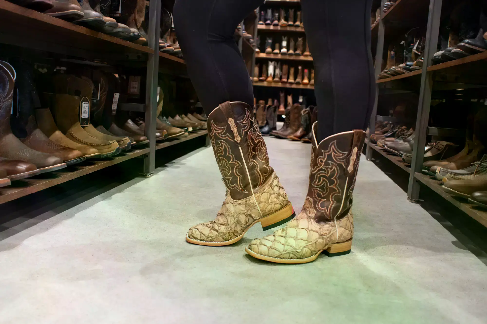 Botas de cowboy de la marca Cody James hechas de piel de pirarucu en una tienda Boot Barn.