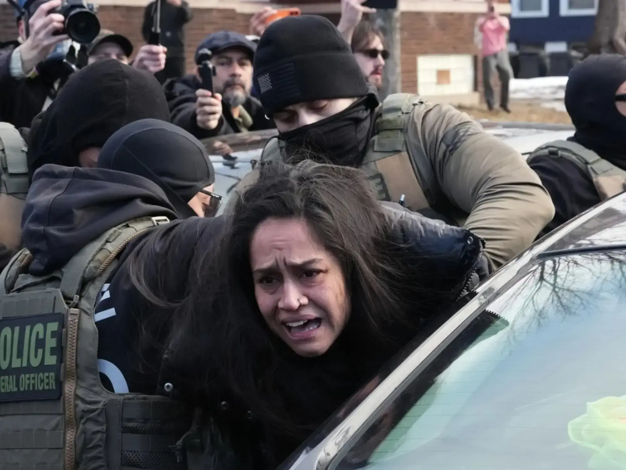 Agentes de ICE sacan a una mujer de su automóvil en Minneapolis.