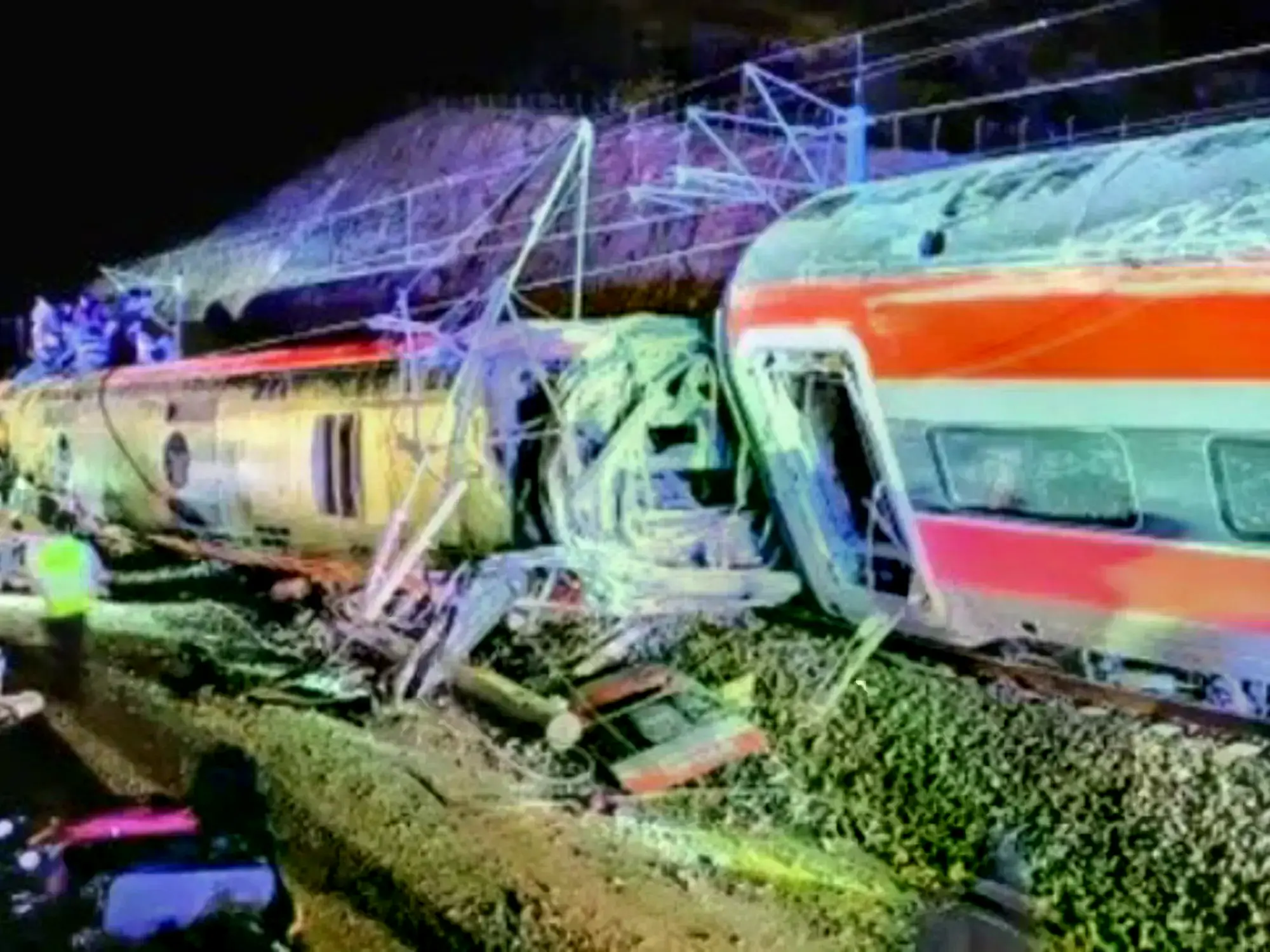 Trenes descarrilados y servicios de emergencia trabajando en el lugar del accidente.