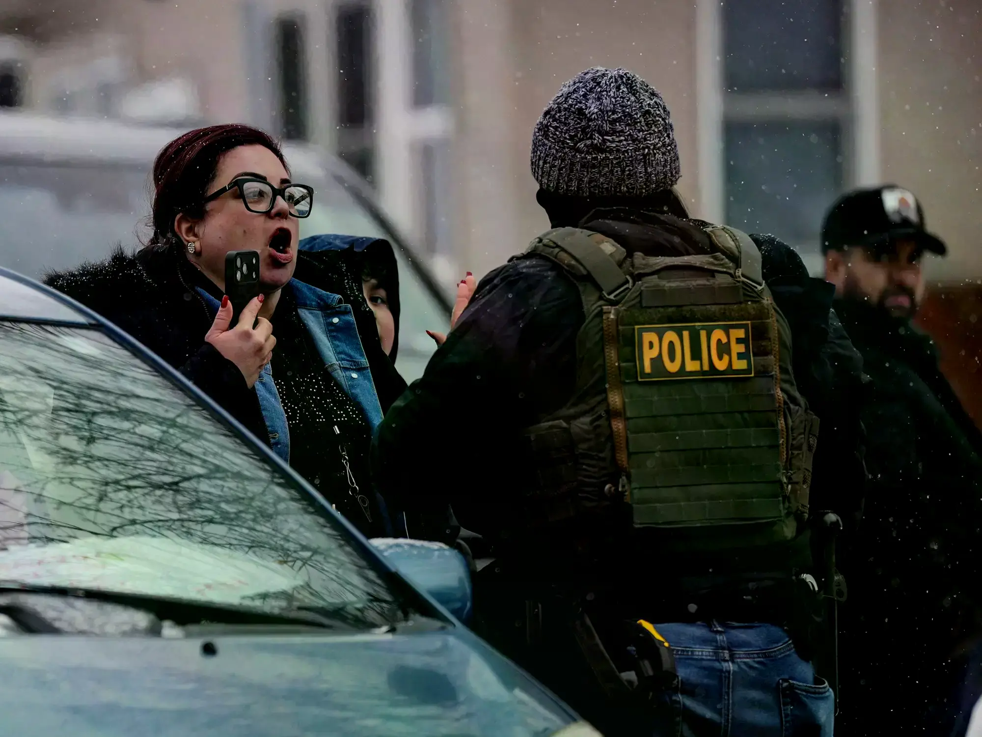 Una mujer discute con un policía durante una redada de inmigración en Minnesota.