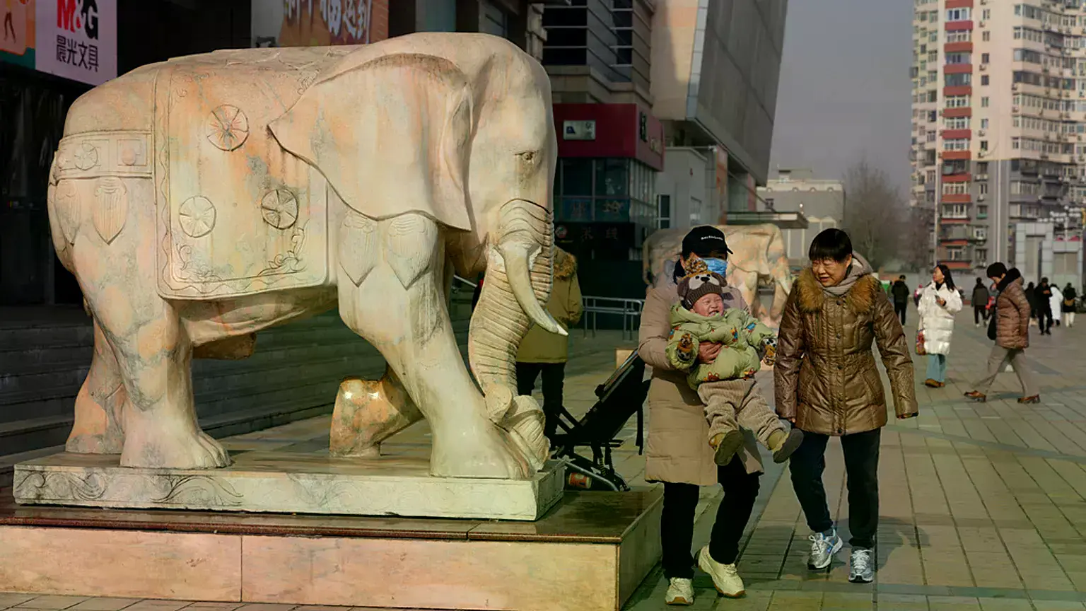 Una mujer alza a un niño en Pekín, China, el 15 de enero de 2026.