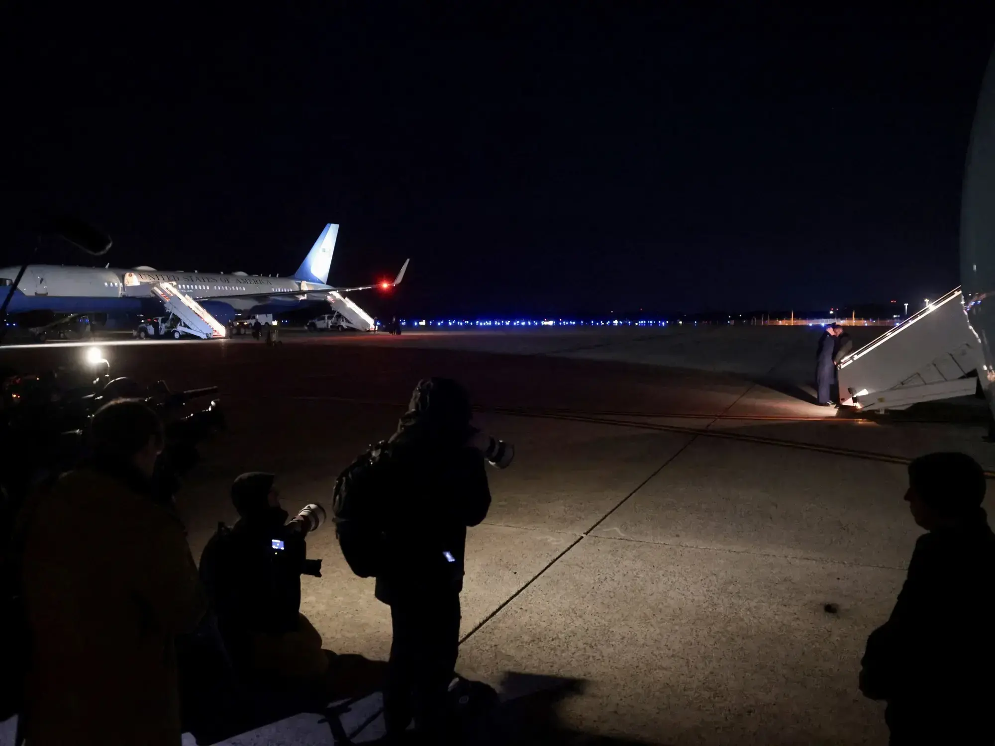 Miembros de los medios de comunicación cambian de avión al abordar otro, también designado Air Force One.