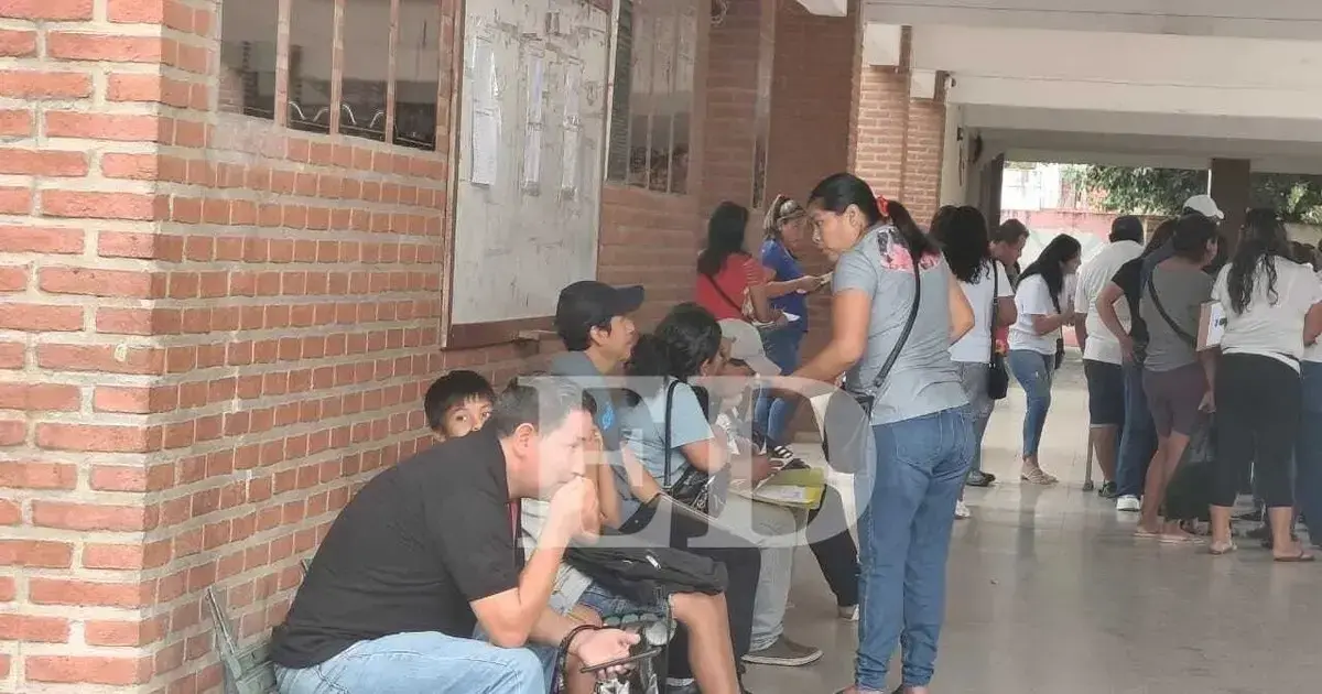 Padres y madres buscan estrategias para 'reservar' su espacio en la fila.
