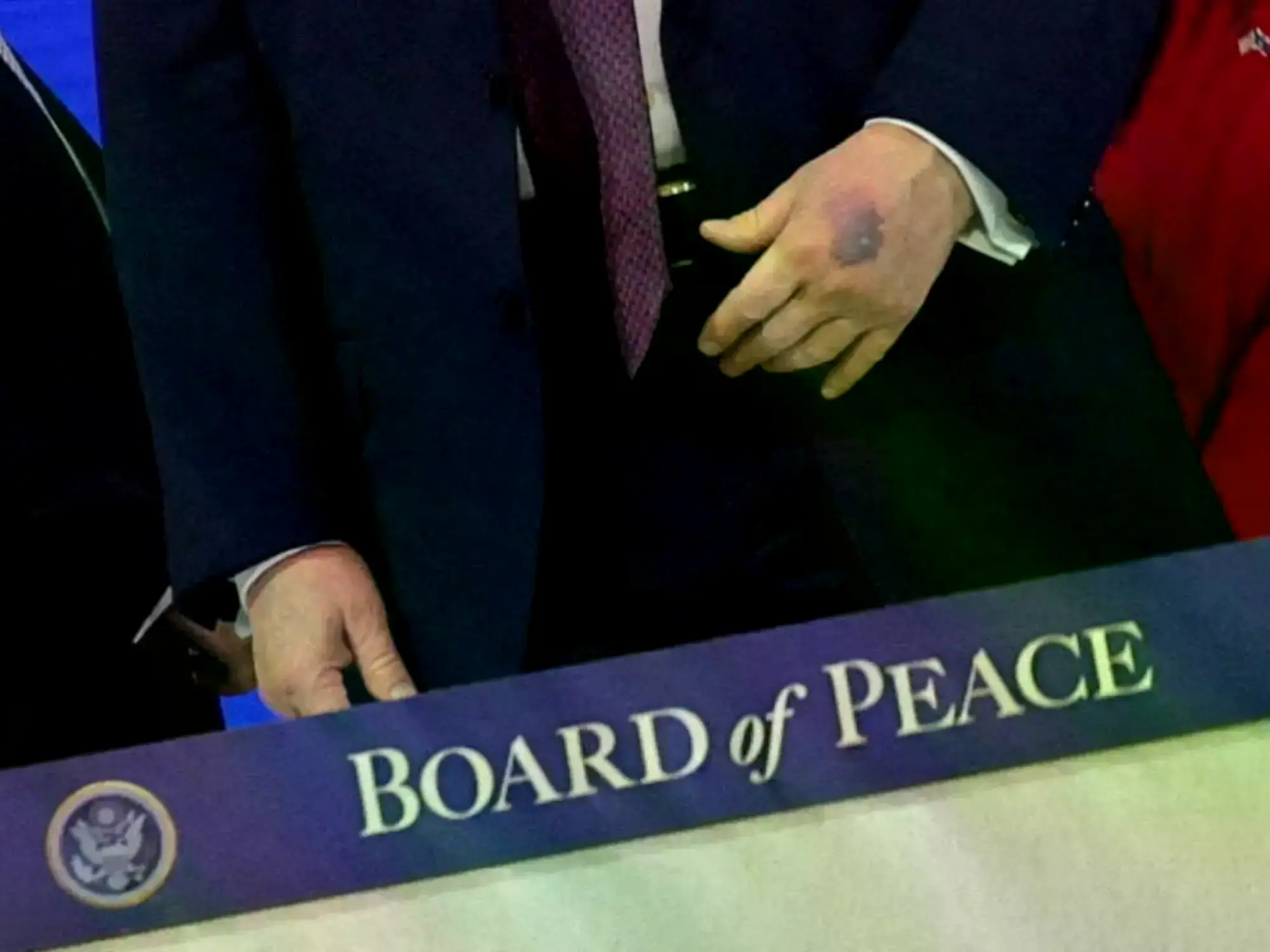 Donald Trump mira sus manos en la ceremonia de firma de la Junta de la Paz.