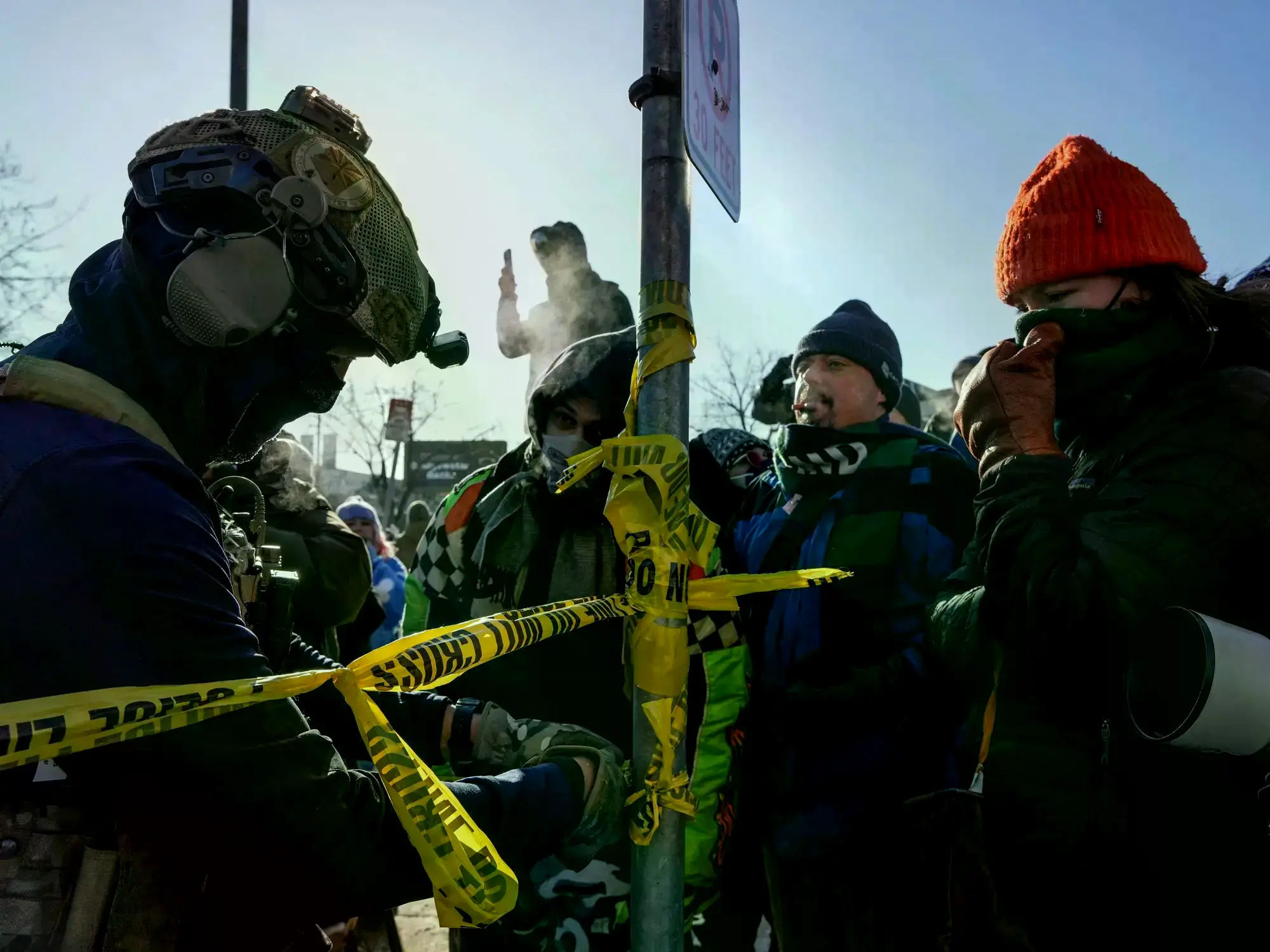 Agente federal acordona el área denunciada como escena de un tiroteo en Minneapolis.