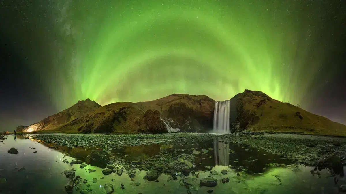 Aurora boreal sobre la cascada Skógafoss en Islandia, capturada por Victor Lima.
