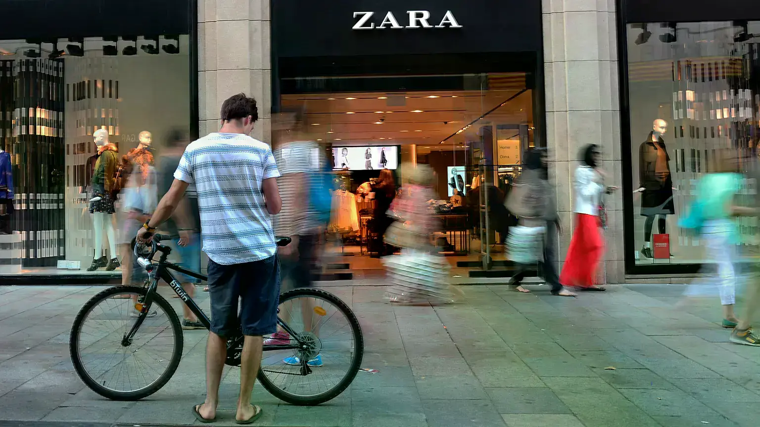 Personas pasan frente a una tienda de Zara en Barcelona en agosto de 2014.