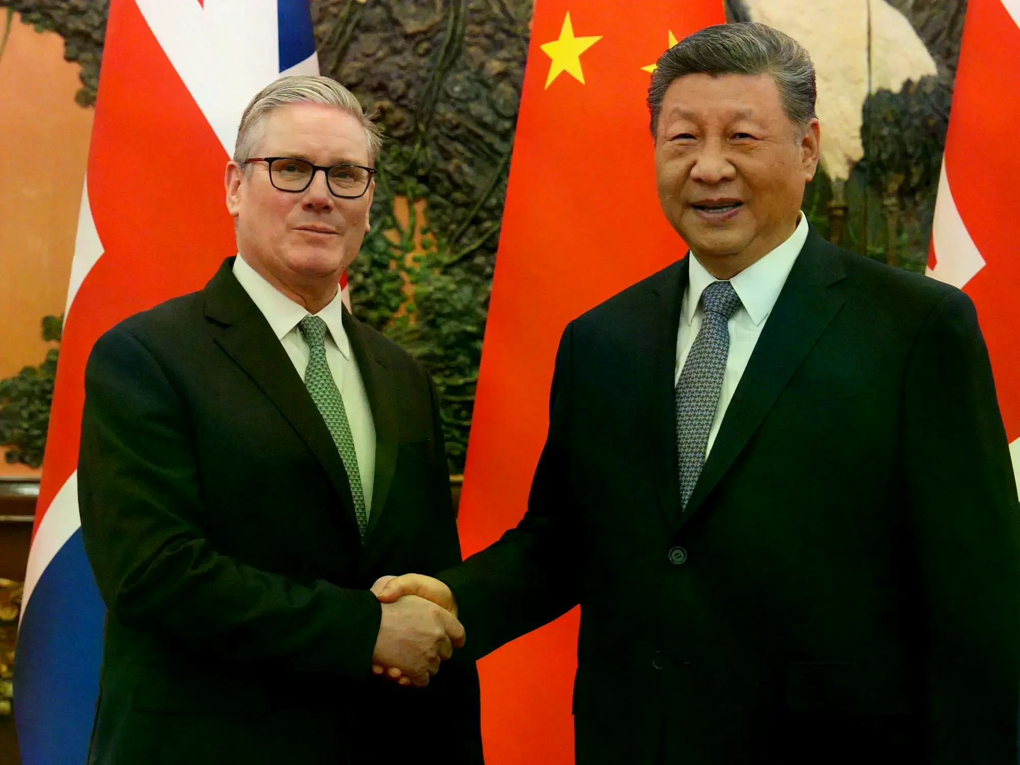 El primer ministro británico Keir Starmer y Xi Jinping se dan la mano en Beijing.