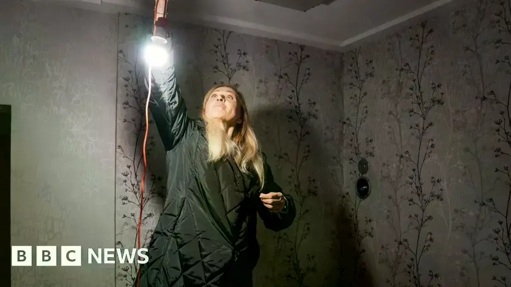 Yulia en su apartamento sin calefacción, usando un abrigo acolchado para combatir el frío.