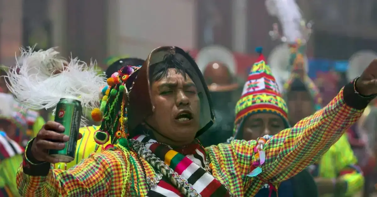Mineros bailan portando sus cascos adornados durante el descenso del Tata Q'ajcha.