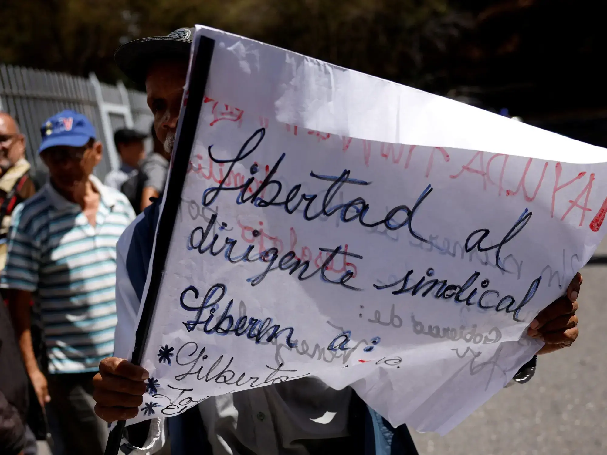 Un hombre sostiene un cartel durante una manifestación frente a un centro de detención policial.