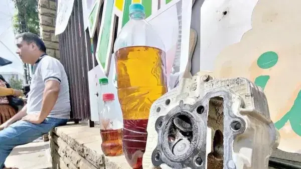 Dueños de vehículos muestran una pieza dañada y gasolina de mala calidad durante una protesta.