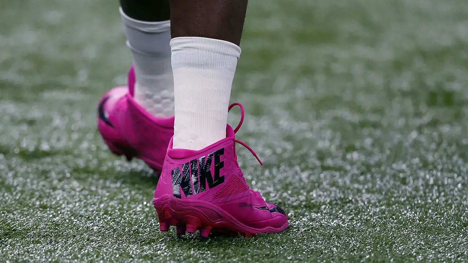 El jugador de Carolina Panthers Kawann Short camina con botas rosas en honor al mes del cáncer de mama antes de un partido de
