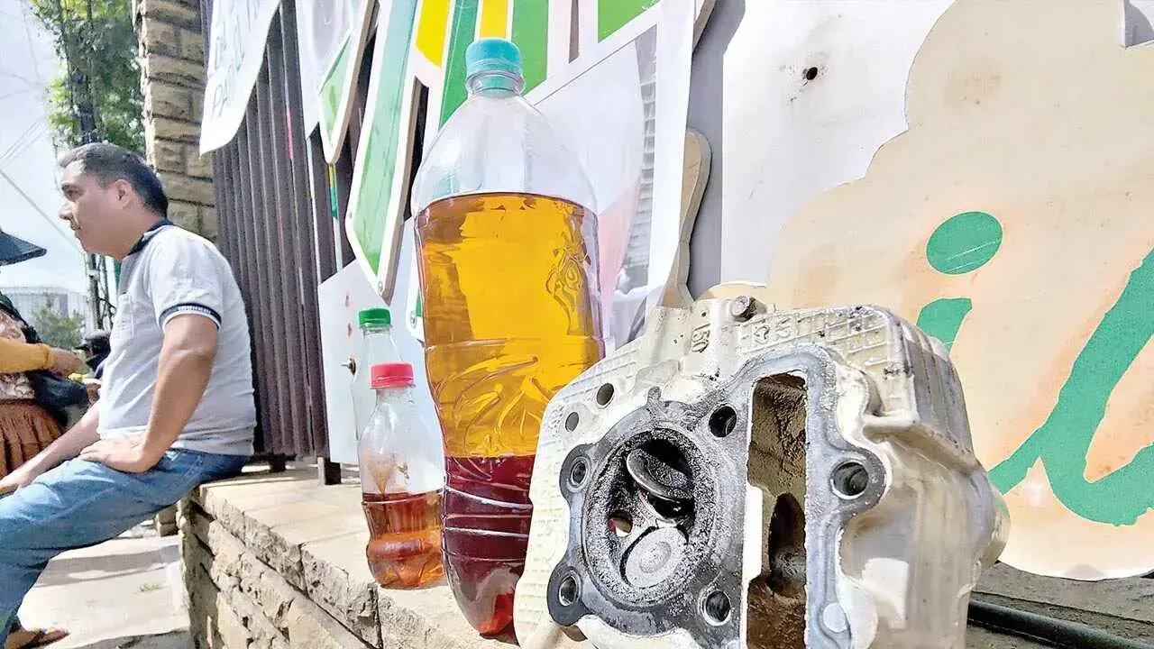 Dueños de vehículos muestran una pieza dañada y gasolina de mala calidad tras una protesta.