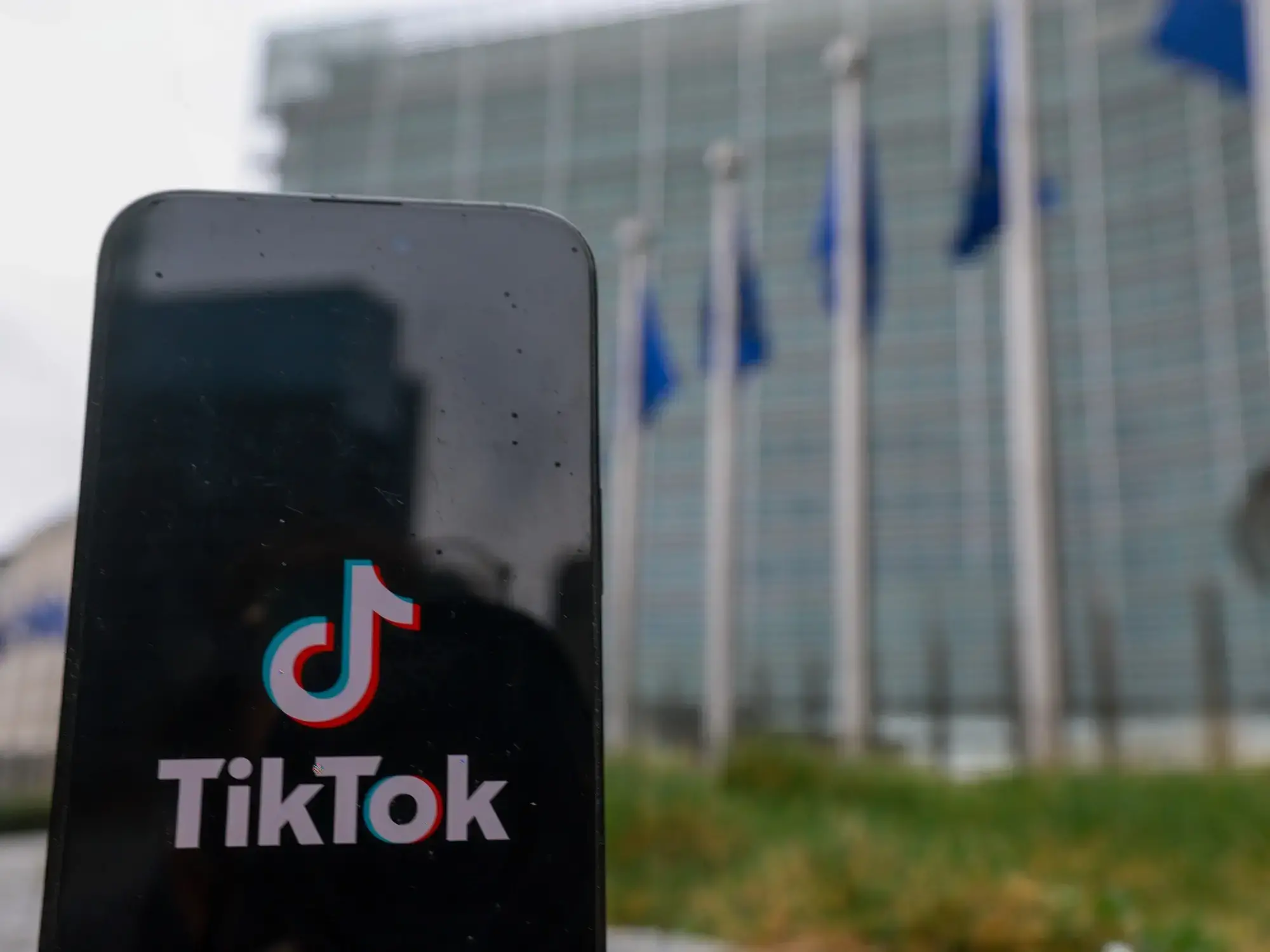 Un teléfono con el logo de TikTok frente la sede de la Comisión Europea en Bruselas.