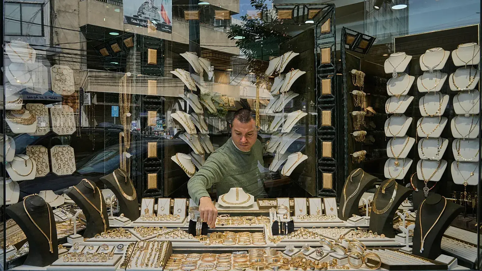 Un joyero coloca adornos de oro en el escaparate de su tienda en el barrio beirutí de Bourj Hammoud.
