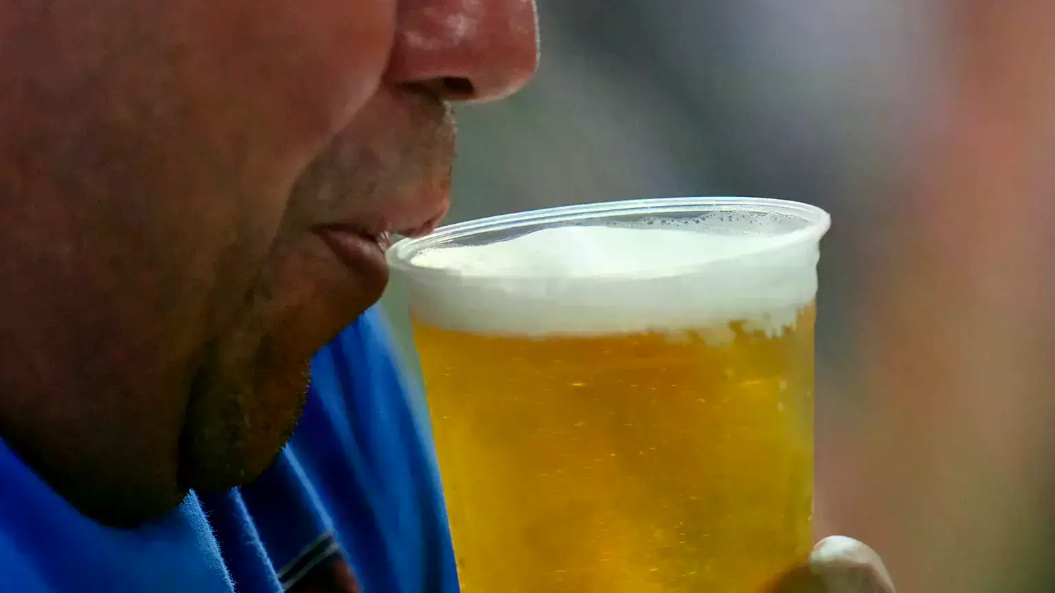 Un aficionado bebe cerveza en un partido de béisbol en Arlington, Texas.