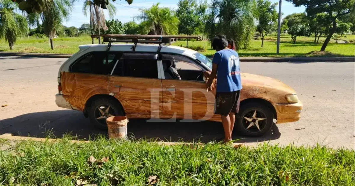 Una persona aplica una mezcla de greda en la carroceria de un automovil.