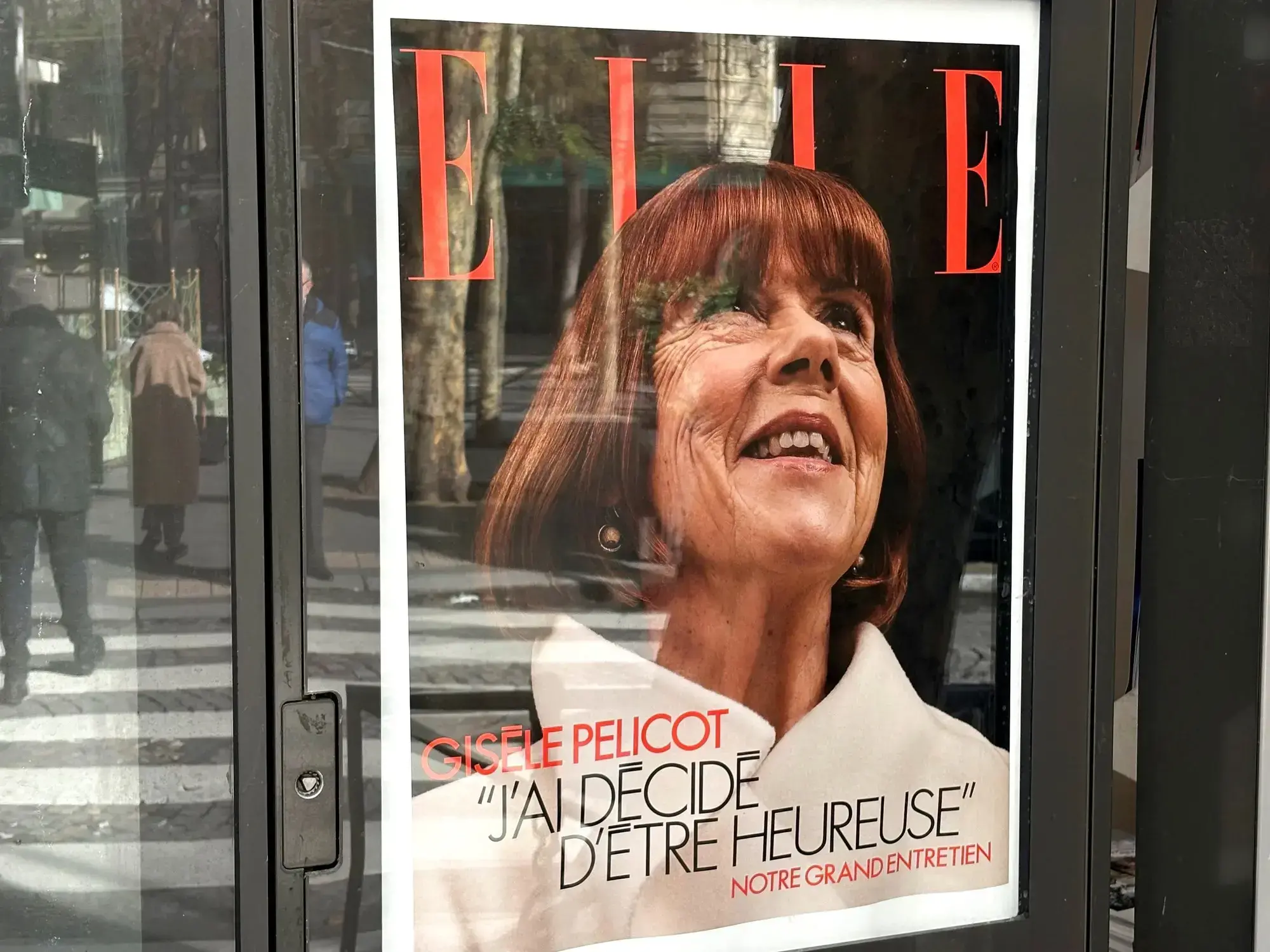 Póster promocional de la entrevista a Gisèle Pelicot para la revista ELLE en un kiosco de París.