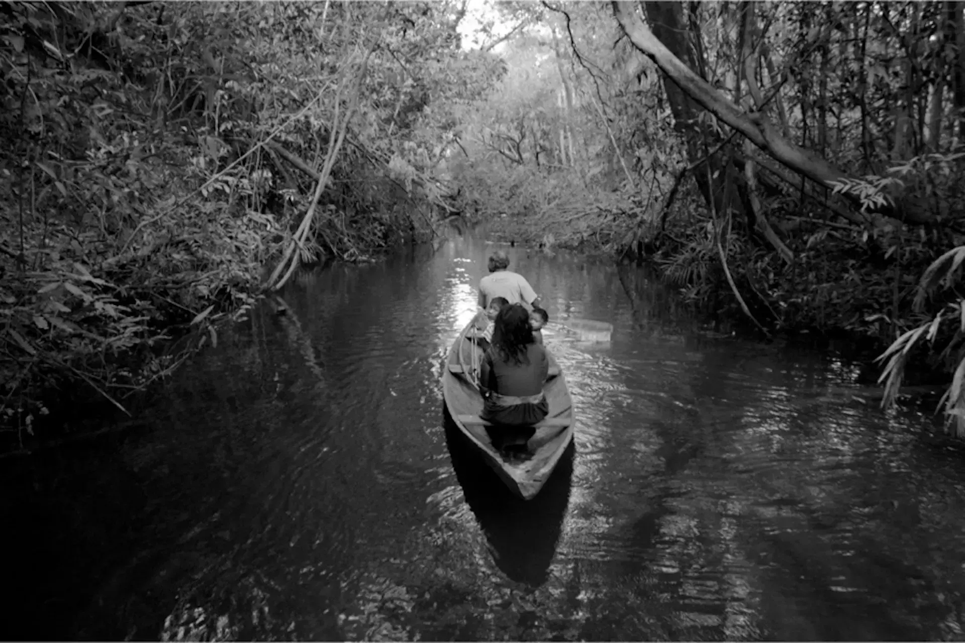 Una familia Pirahã navegando por un río en la Amazonía.