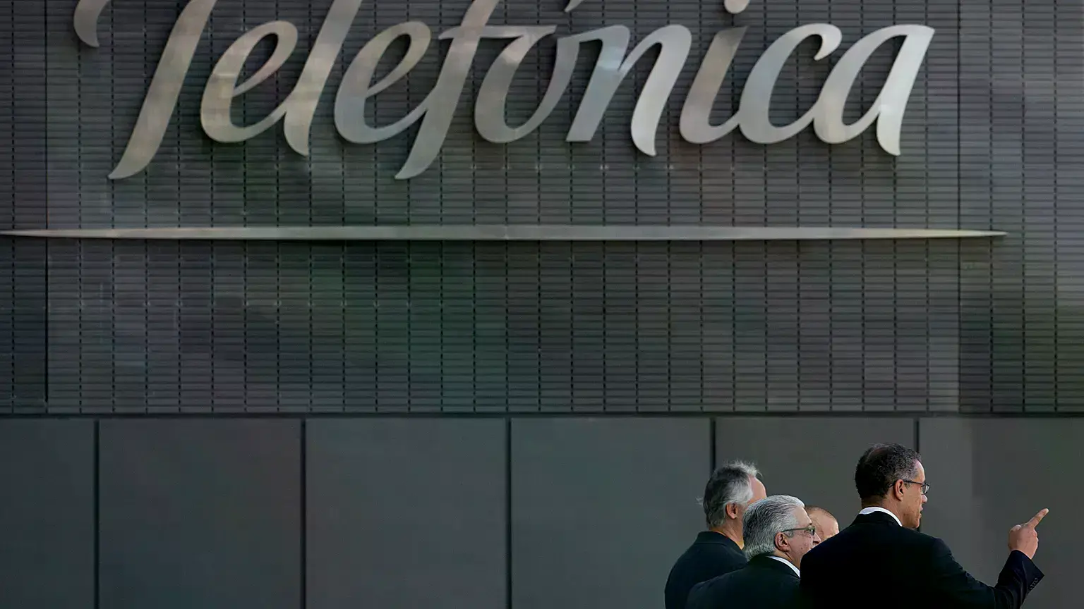 Hombres salen de la sede central de Telefónica en Madrid, julio de 2013