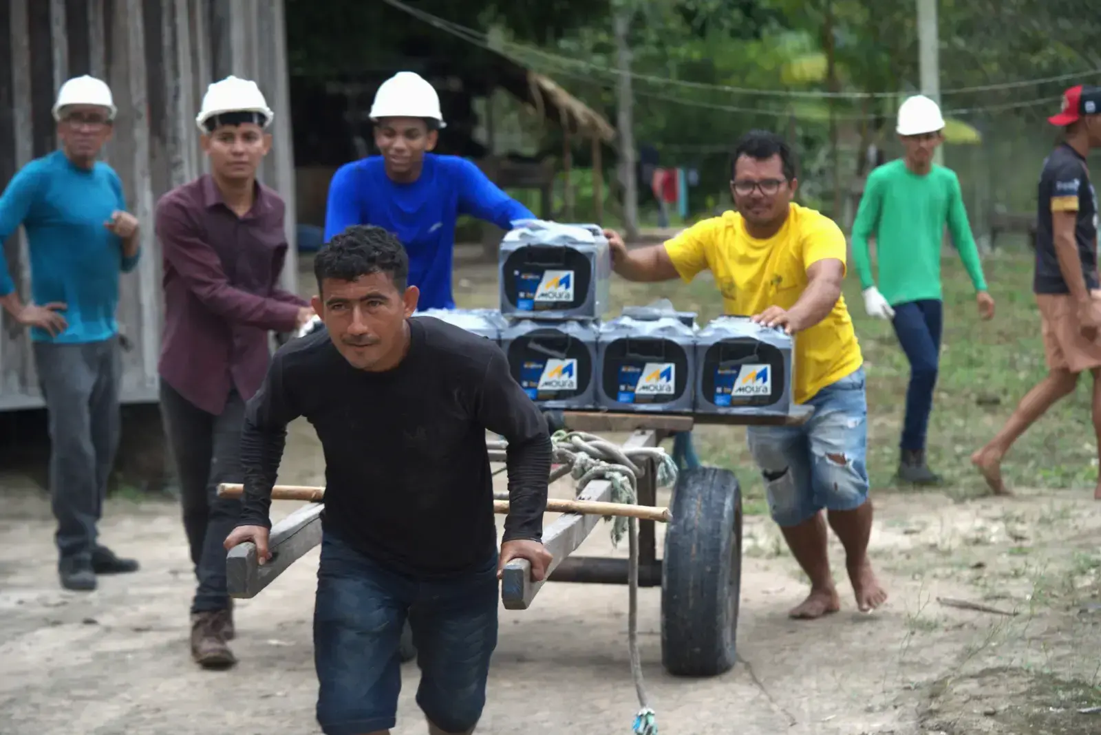 Residentes de la comunidad Porto Rico transportan equipos para construir sistemas de energía autónomos.