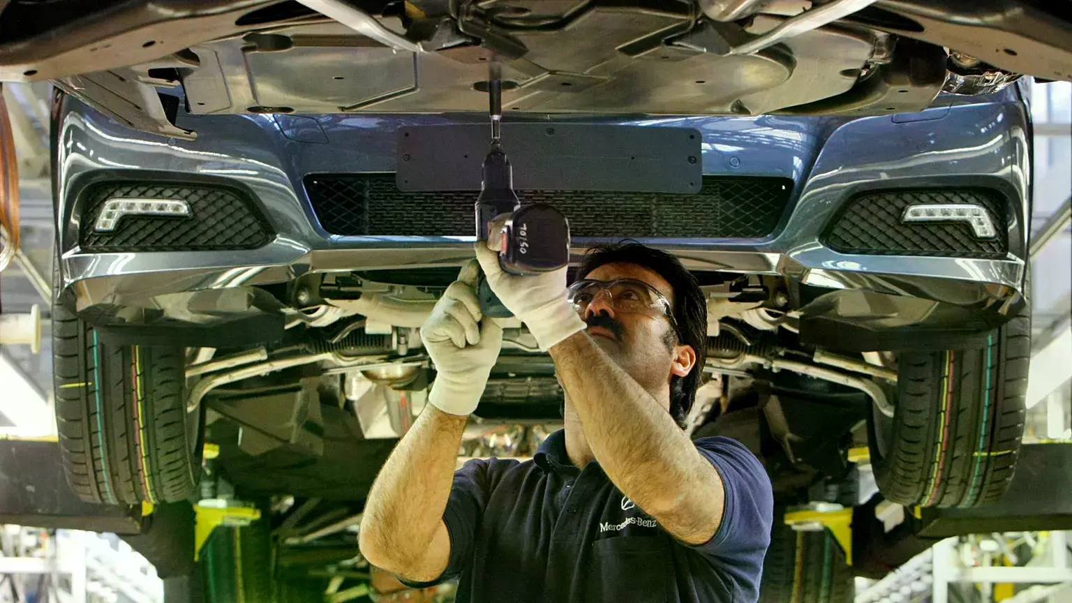 Un empleado trabaja en un turismo Mercedes-Benz Clase E en la planta de producción de Sindelfingen, Alemania.