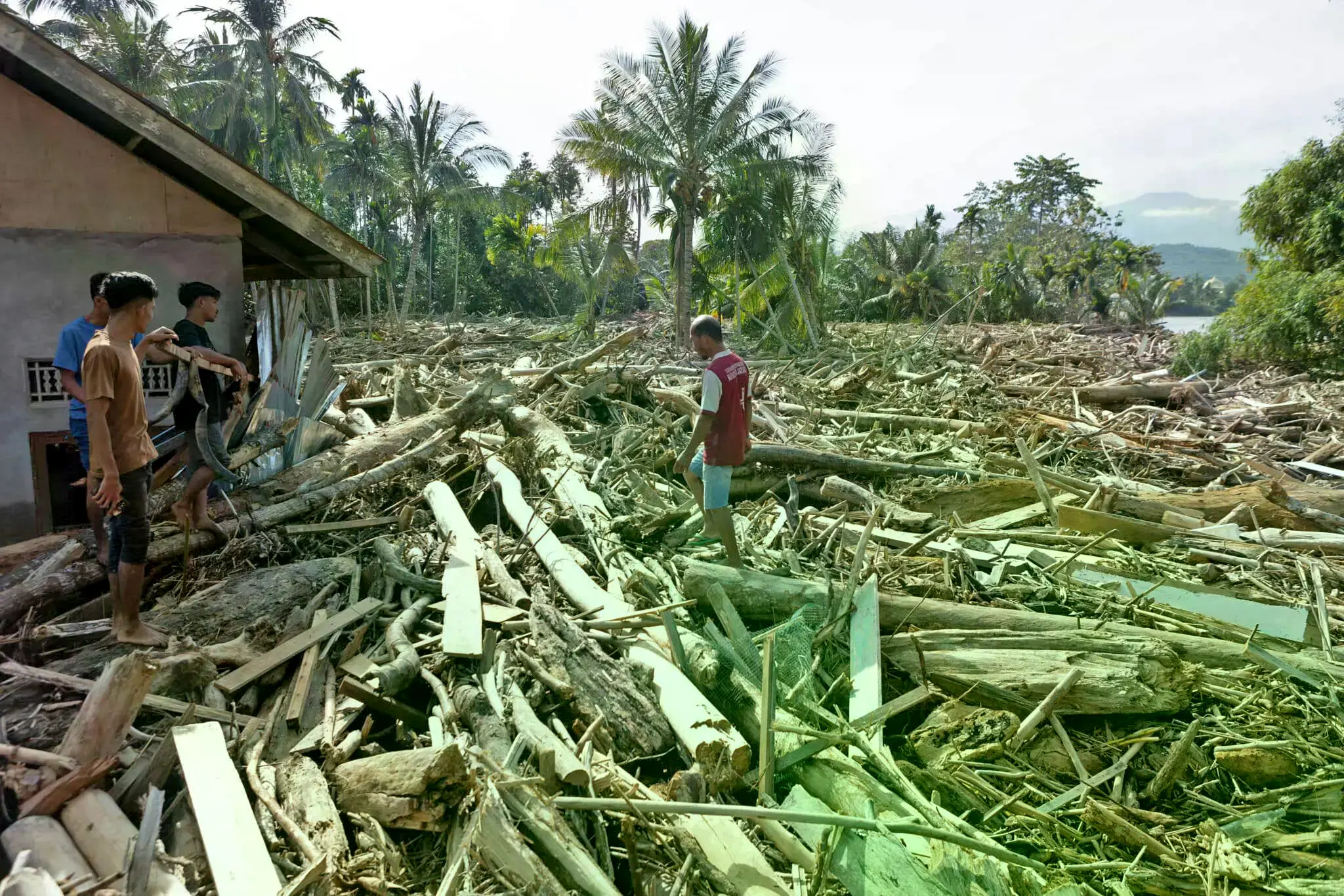 Una mujer cerca de una tienda dañada durante una inundación en la provincia de Aceh, Indonesia.