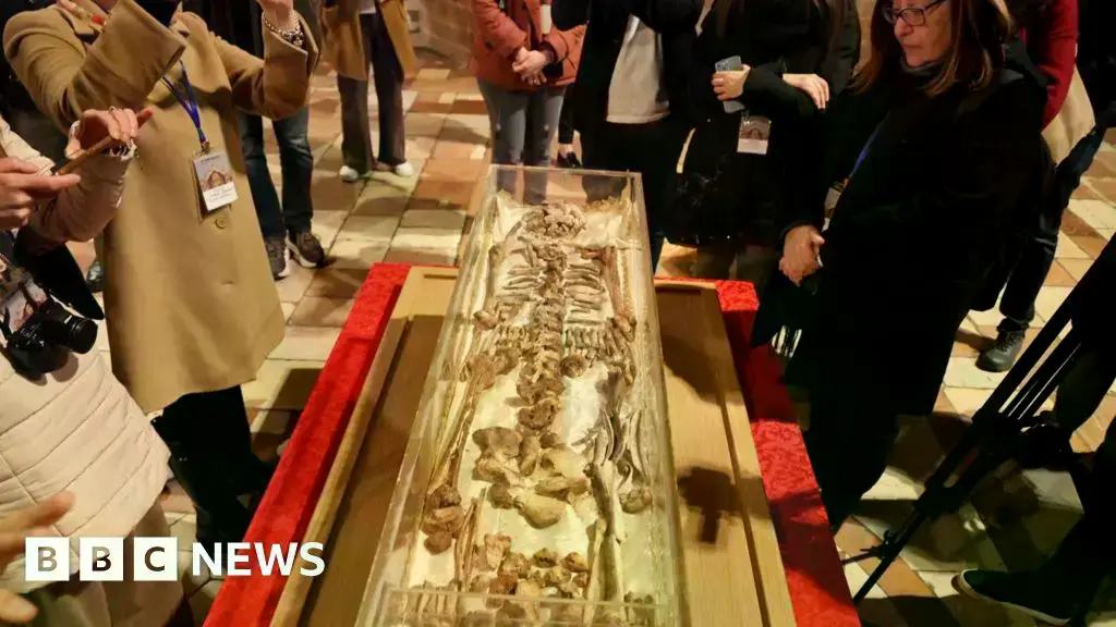 El esqueleto se exhibe en una urna de plexiglás llena de nitrógeno delante del altar de la basílica inferior.