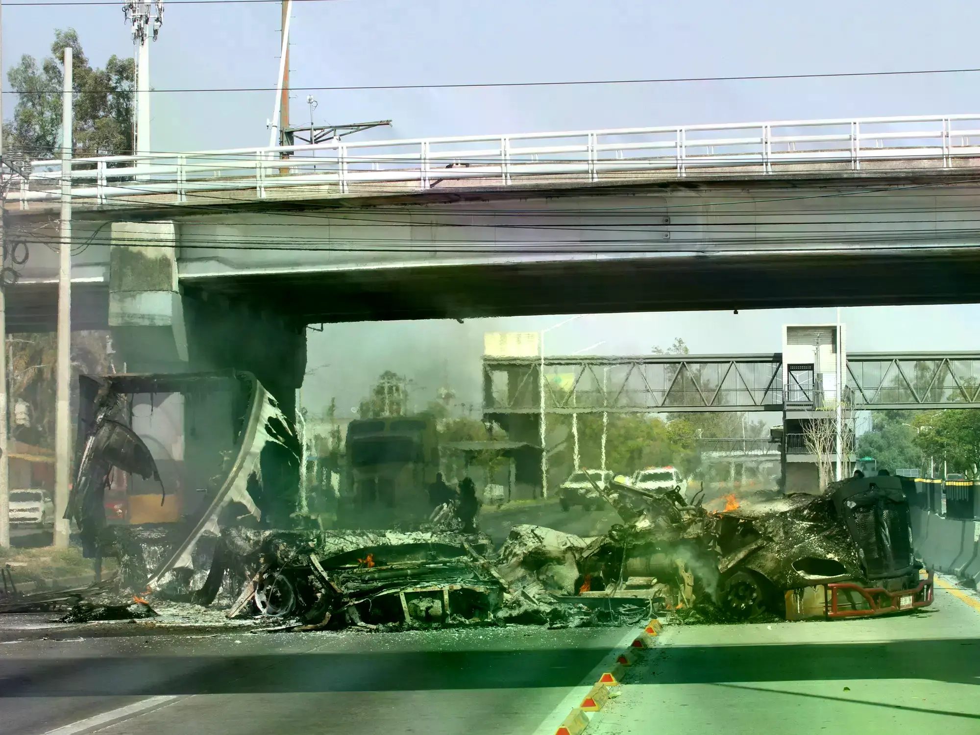 Escombros de un vehículo quemado en una calle durante un estado de código rojo en Guadalajara, Jalisco.