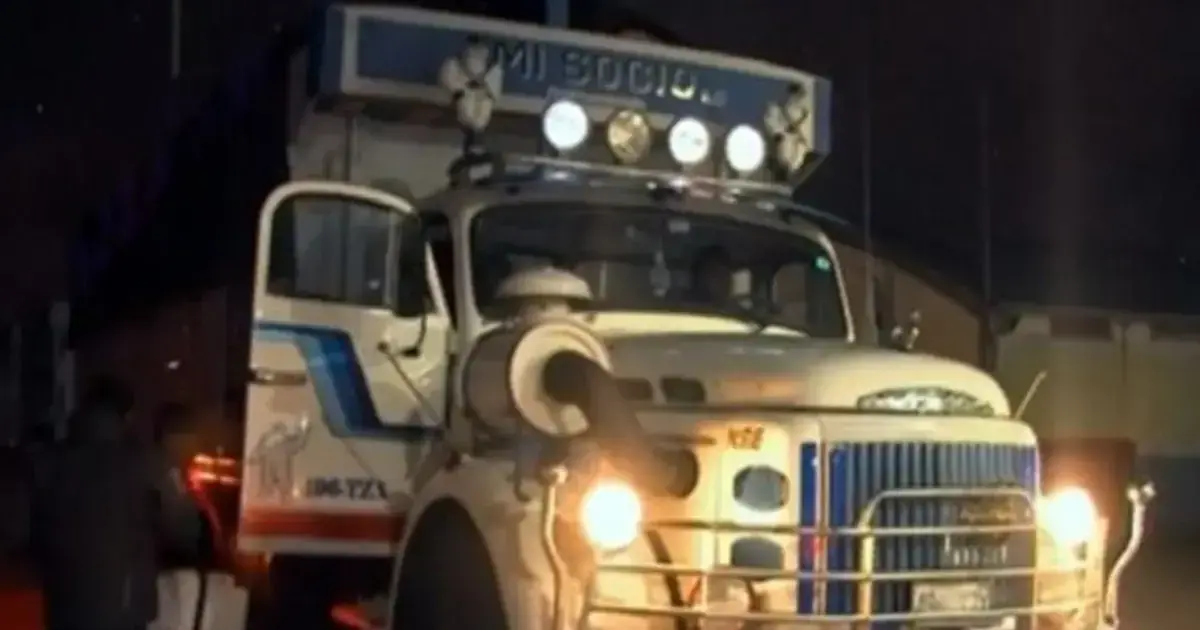 El camión de Mi Socio lidera la caravana en una noche lluviosa.