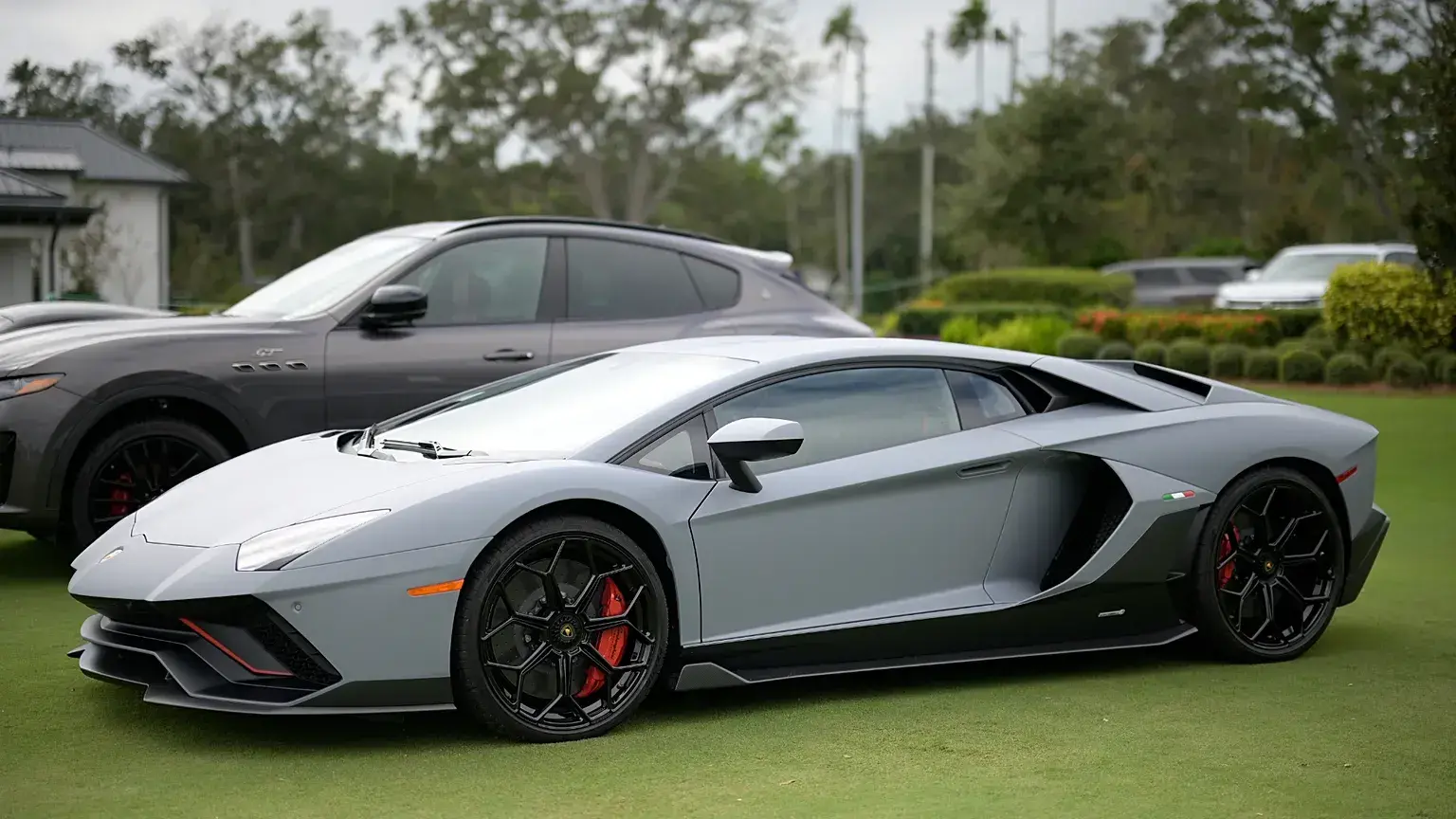 Un deportivo Lamborghini expuesto en un campo de prácticas de golf.