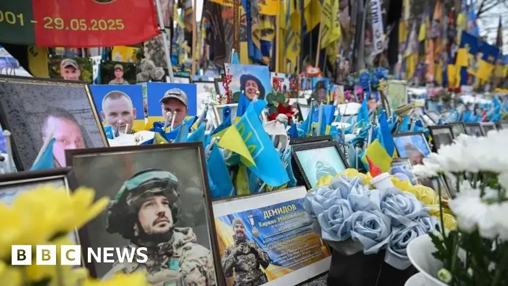 Personas guardan silencio en la plaza Maidan de Kyiv durante el aniversario.