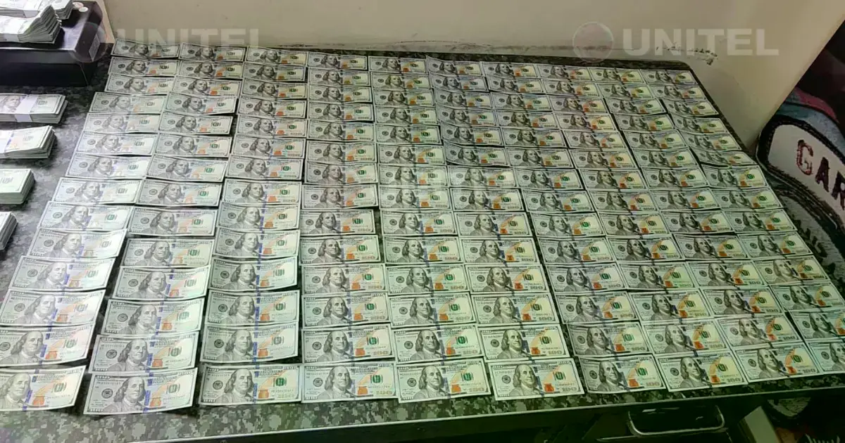 Personal policial muestra billetes falsos incautados.