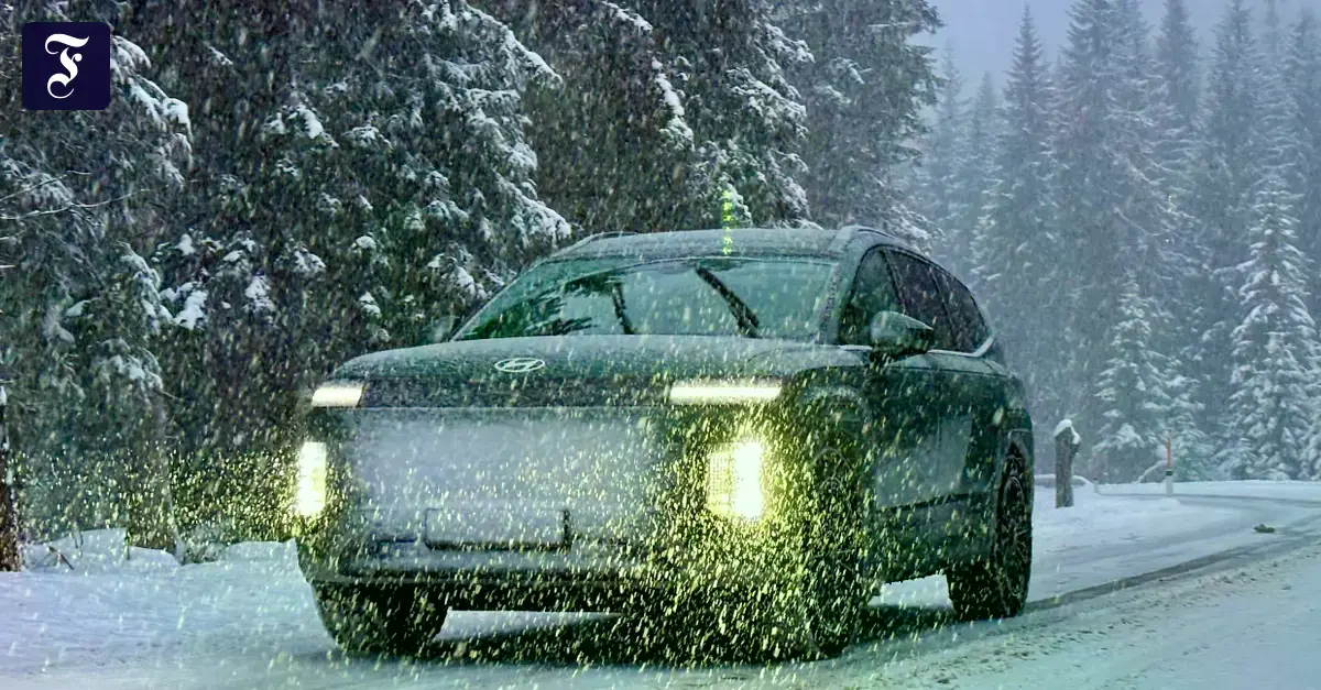 Un Hyundai eléctrico con tracción total subiendo una pista nevada.