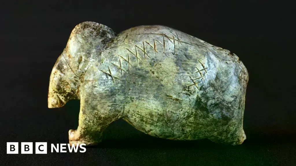 Figurilla de mamut de 40.000 años con filas de cruces y puntos grabados.